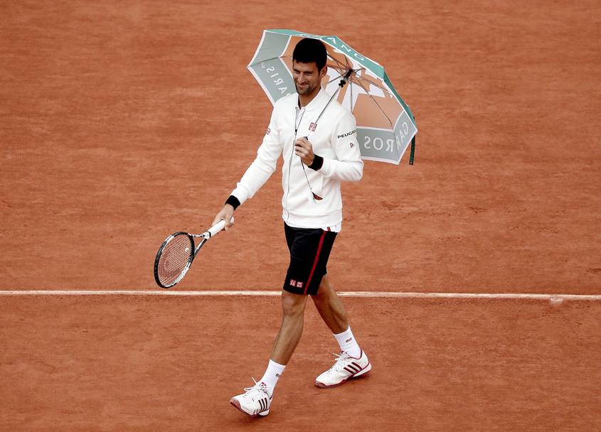 Djokovic verifica le condizioni del campo dopo che la gara  stata interrotta a causa pioggia battente (Epa)